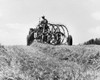 Farmer sitting on a tractor in a hay field Poster Print - Item # VARSAL25530513