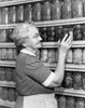 Senior woman choosing a jar of pickled vegetables Poster Print - Item # VARSAL25549200