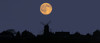 A glowing full harvest moon over the silhouette of a skyline of buildings; Whitburn, Tyne and Wear, England Poster Print by John Short / Design Pics - Item # VARDPI12320296