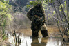 A sniper dressed in a ghillie suit crosses a stream while on patrol Poster Print by Stocktrek Images - Item # VARPSTSTK104447M