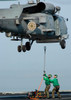 Airmen assist each other as they hook a sling to an SH-60B Seahawk Poster Print by Stocktrek Images - Item # VARPSTSTK100061M