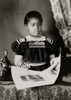 African American girl, half-length portrait, standing at table with illustrated book, facing slightly right Poster Print - Item # VARBLL0587634456