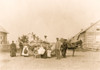 Group portrait of St. Regis Mohawk men and women with examples of baskets, standing in the street with P. Daly, the basket buyer. Poster Print - Item # VARBLL058751316L