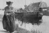 A Older Dutch woman has a bustle around her chest as she pulls a barge down a canal. Poster Print by unknown - Item # VARBLL058745910L