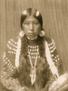 Kalispel Indian woman, half-length portrait, facing front, seated, wrapped braids, white stripes painted on hair, shell disk earrings, wearing blanket dress decorated with elks' teeth. Poster Print - Item # VARBLL058747574L