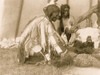 Three Dakota men, seated or kneeling on ground, one attending to bison skull. Poster Print - Item # VARBLL058746926L