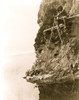 Hupa man sitting on a platform on a rocky cliff, handling a fishing net. Poster Print - Item # VARBLL058746939L