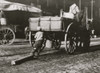 Boys hooks a log or piece of wood to the back of a cart where an unknowing teamster in his wagon pulls the boy and the wood to where the youngster is going. Poster Print - Item # VARBLL058754435L