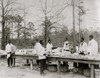 African American men preparing to serve a meal in an outdoor setting among trees Poster Print - Item # VARBLL0587631856