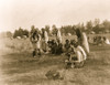 Group of Cheyenne people, most seated in a semicircle during sun dance ceremony, woman in foreground is holding pipe, buffalo skull in foreground. Poster Print - Item # VARBLL058747124L