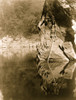 Yurok man standing on rock ledge holding fishing line in one hand and pole down into the water below with the other hand. Poster Print - Item # VARBLL058746928L