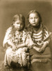Two girls, full-length, seated, facing front, with loose hair, one wearing buckskin dress decorated with elks' teeth, one wearing beaded cloth dress. Poster Print - Item # VARBLL058747506L