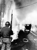 National Guard In Watts During The 1965 Race Riot. Debris Litters The Streets And A Geyser From Broken Fire Hydrant Sprays At Left. August 14 History - Item # VAREVCCSUA001CS688