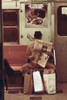 New York City Subway. A Passenger Is In His Own World Reading His Newspaper With His Shopping Bags Secured Between His Feet. May 1973. History - Item # VAREVCHISL031EC155