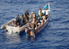 U.S. Navy Sailor Inspects The Outboard Engines On A Skiff Suspected Of Participating In Recent Pirate Activity While Fellow Sailors Board Search And Question Men On Ship. May 31 2010 In The Gulf Of Aden. History - Item # VAREVCHISL024EC255