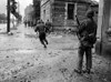 U.S. Soldiers Moving Through The Streets Of Cherbourg. One By One They Dash Across A Street To Evade German Sniper Fire. June 22-25 History - Item # VAREVCHISL037EC229