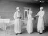 Surgical Nurse Assists Surgeons Into Rubber Gloves Before An Operation. 1922 In A Hospital In Washington History - Item # VAREVCHISL043EC210