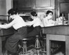 Spanish Flu Epidemic 1918-1919 In America. Young Women Office Workers With Gauze Mask Carefully Tied About Their Faces To Protect Against The Spread Of Influenza. Oct. 16 History - Item # VAREVCHISL043EC498