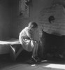The Great Depression. Young Girl Sitting On Bench Near Fireplace With Bed In Background In A Taos History - Item # VAREVCHISL008EC178