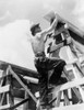 Civilian Conservation Corps At Work. Enrollee William L. Cross Climbing Up On A Scaffold Erected For Assembling A Prefabricated Building To Be A Camp Work Shop History - Item # VAREVCHCDLCGAEC838