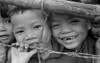 Smiling Youngsters Press Against A Barbed Wire Fence. There Were 126 Families History - Item # VAREVCHISL033EC319