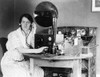 Woman Listening To Radio In Her Home Receiving A Personal Radio Message Telling Her When Her Husband Will Arrive Home. 1922. History - Item # VAREVCHISL012EC201
