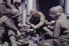 U.S. Army Engineer Unit Stationed In Cherbourg Prepares A Meal Of Rations In A Doorway. Shortly After The German Surrender Fresh Food Was Not Available To Troops. June-July 1944. Normandy Campaign History - Item # VAREVCHISL037TX306