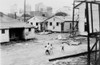 African American Children Playing In Slum In View Of High Rise Buildings In Background. North Carolina History - Item # VAREVCHISL011EC213