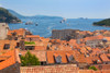 Dubrovnik, Dubrovnik-Neretva County, Croatia. View over rooftops of the old town from the Minceta Tower. Boats in the Old Port. Cruise boats under way. The old city of Dubrovnik is a UNESCO World Heritage Site. Poster Print by Panoramic Images - Item