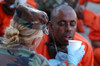 U.S. Military Police Woman Provides Water To A Thirsty Detainee As They Arrive At Camp X-Ray At Guantanamo Bay Naval Base. The Prisoners Were Believed By The U.S. Military To Be Associated With Al-Qaeda Or The Taliban. Feb. 11 2002. - Item # VAREVCHI