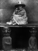 Kwakiutl Woman, 1914. /Nthe Daughter Of A Kwakiutl Chief In British Columbia, Seated On A Blanket-Covered Board Supported By Two Carved Wooden Figures Representing Her Slaves. Photograph By Edward Curtis, 1914. Poster Print by Granger Collection - It