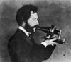 Alexander Graham Bell /N(1847-1922). American (Scottish-Born) Teacher And Inventor. An Actor Portrays Bell Speaking Into His Centennial Telephone At The Philadelphia Centennial International Exhibition In June 1876, In A Filmed Reenactment Of 1926. P