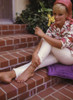 Elke Sommer - Sitting on brick stairs/ Smelling yellow flower Photo Print (8 x 10) - Item # DAP18113