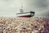 A fishing boat sits on the rocky beach under a cloudy sky; Hastings, England Poster Print by Melody Davis / Design Pics - Item # VARDPI12388232