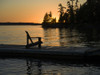 A wooden Adirondack chair sits on a dock on a tranquil lake at sunset; Lake of the Woods, Ontario, Canada Poster Print by Keith Levit / Design Pics - Item # VARDPI12511939