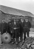 A historical image of a group of men standing together in suits and hats, one holding a saw blade and oil can Poster Print by John Short / Design Pics - Item # VARDPI12512138