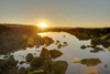 A golden-coloured sunset and sunburst hilights the rocks around an ocean-side pool of water; Chubut, Argentina Poster Print by Philippe Widling / Design Pics - Item # VARDPI12534187