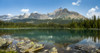 Mountain range reflecting on an alpine lake with a rocky shoreline and blue sky and clouds; British Columbia, Canada Poster Print by Michael Interisano / Design Pics - Item # VARDPI12546273