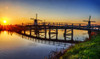 Netherlands, Kinderdijk. Windmill and bridge along the canal at sunrise Poster Print by Terry Eggers - Item # VARPDDEU18TEG0097