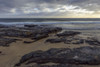 Rocky beach and the surf of the North Sea at Bamburgh in Northumberland, England, United Kingdom Poster Print by Raimund Linke (19 x 12)