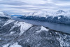 Aerial landscape image of Tutshi Lake on a grey day with dramatic clouds with snow capped mountains in winter; Yukon, Canada Poster Print by Robert Postma (19 x 12)
