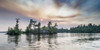 Sun glowing in clouds over a lake and forest at sunset, Lake of the Woods, Ontario; Kenora, Ontario, Canada Poster Print by Keith Levit (23 x 11)