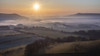 The sunrise casts long shadows over a morning mist inversion lying over the English countryside in South Downs National Park; Lewes, East Sussex, England Poster Print by Stuart Short (19 x 11)