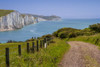 View down the path to the coastguard cottages with the Seven Sisters and Belle Tout Lighthouse in the distance. Poster Print by Loop Images Ltd. (17 x 11)