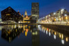 The Mann Island complex reflects off the water of the Canning Dock in Liverpool during twilight. Poster Print by Loop Images Ltd. (18 x 12)