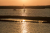 A sailing boat and dinghy against an orange sky at  Burnham Overy Staithe. Poster Print by Loop Images Ltd. (20 x 13)