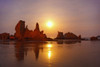 Silhouetted rock formations on Bandon Beach at sunset at low tide, Oregon coast; Oregon, United States of America Poster Print by Craig Tuttle (17 x 11)