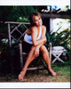 Tia Carrere Sitting In Wooden Chair Outdoors Photo Print - Item # MVM55328