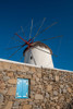 A traditional windmill set behind a rock masonry wall Chora-Mykonos Island-Greece Poster Print - Sergio Pitamitz