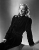 Ingrid Bergman sitting on a Couch in a Long Sleeve Dress with Brooch Photo Print - Item # VARCEL681982